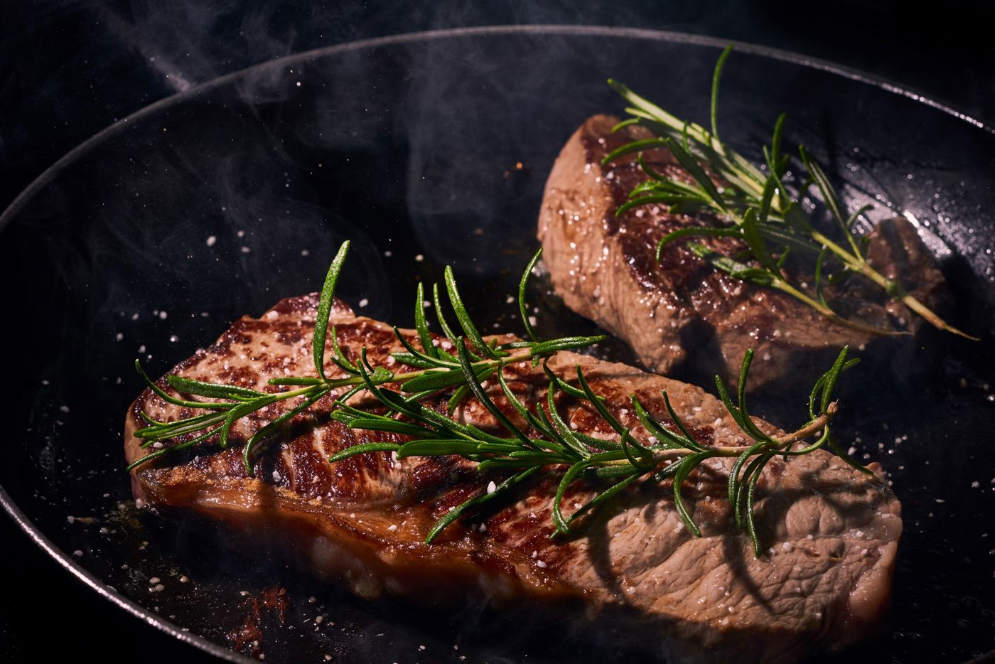 Smakelijk gerecht met steak geserveerd op een zwart bord gegarneerd met kruiden Eetcafé De Drie Noten